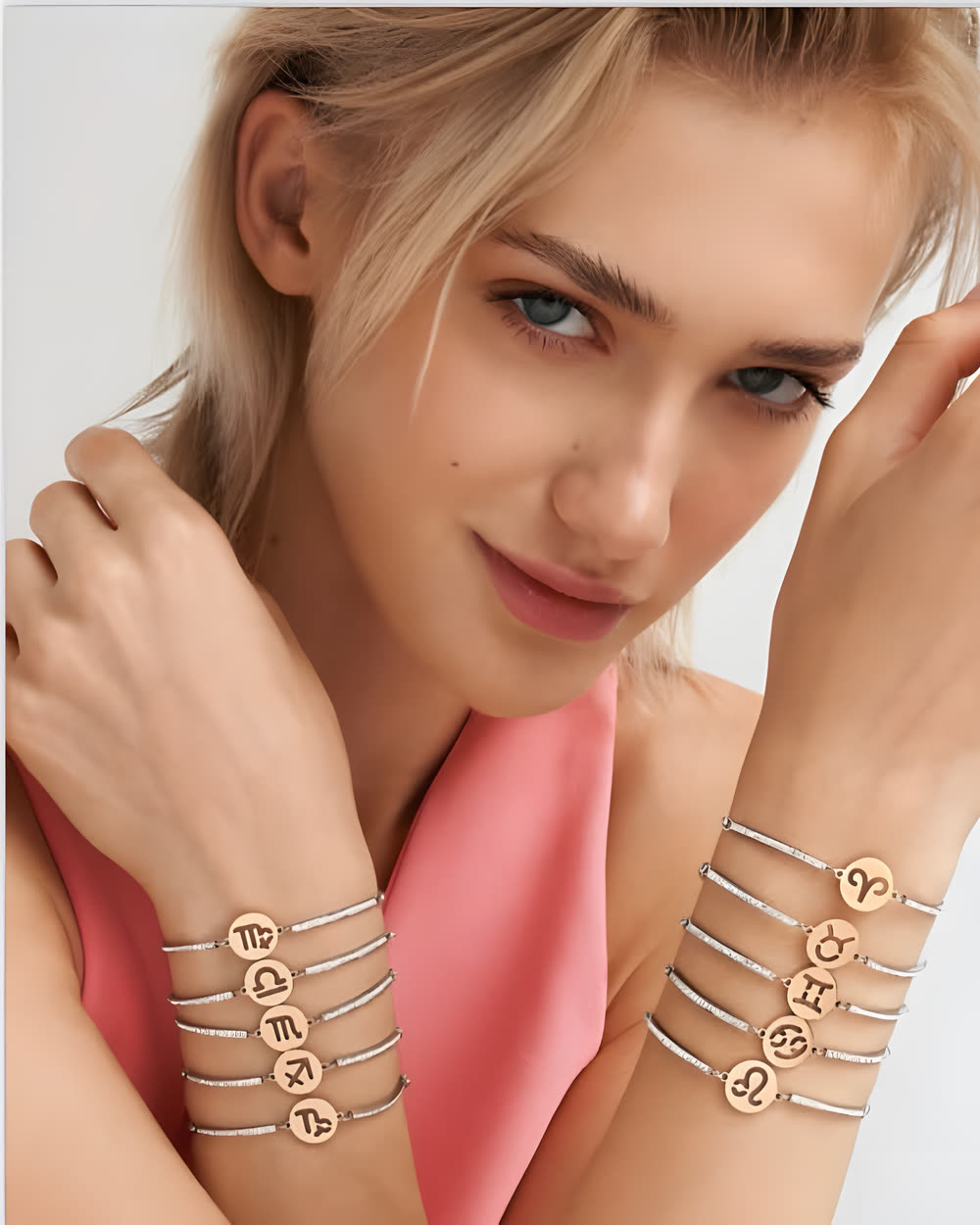 Chica con varias pulseras finas con medallitas de letras en las dos muñecas